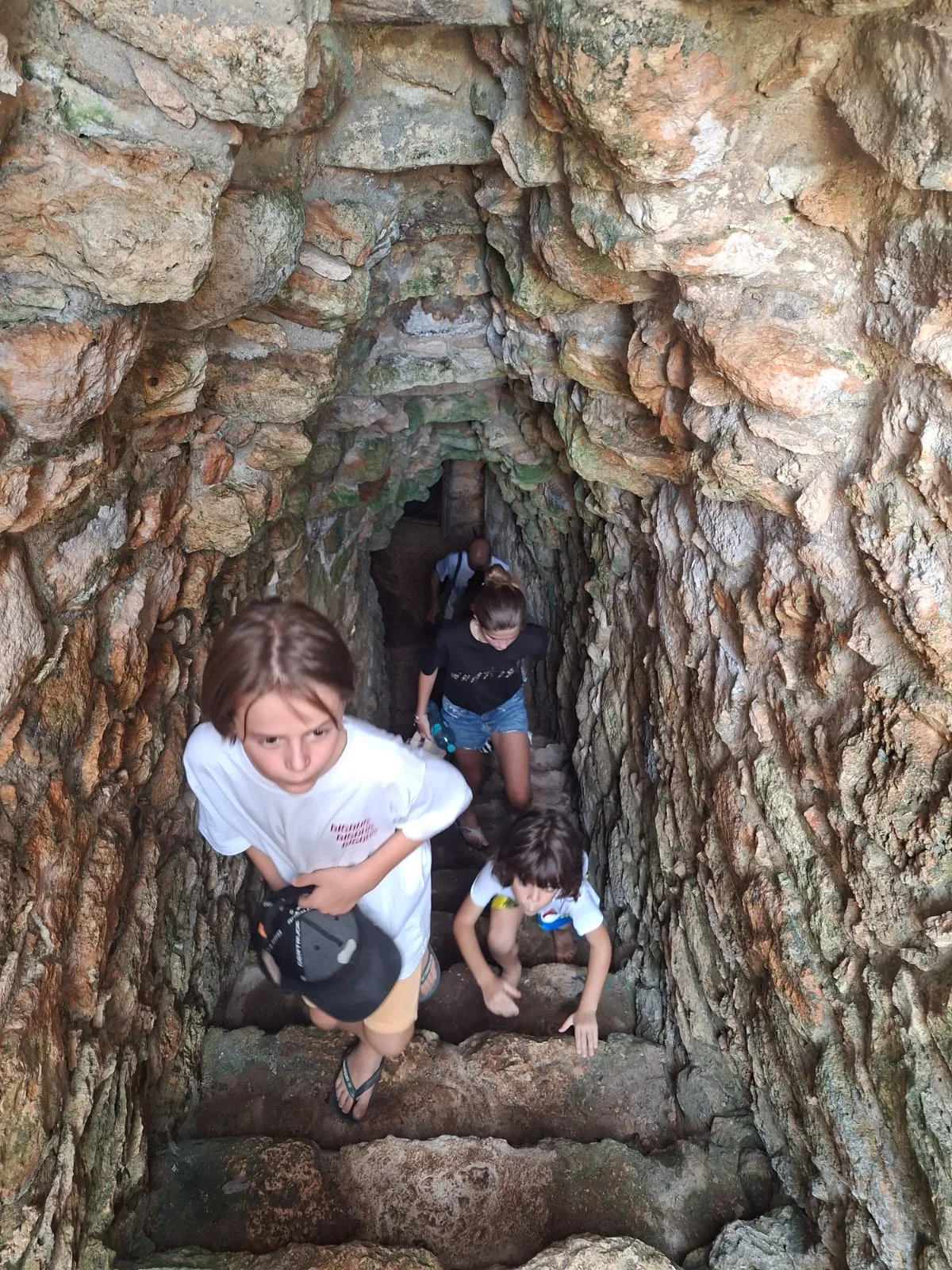 Visitantes subiendo por un pasaje interior de piedra