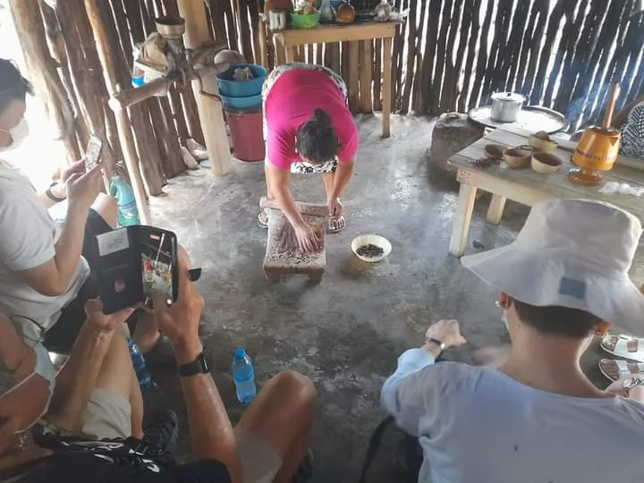 Molienda del cacao en metate, ante el grupo