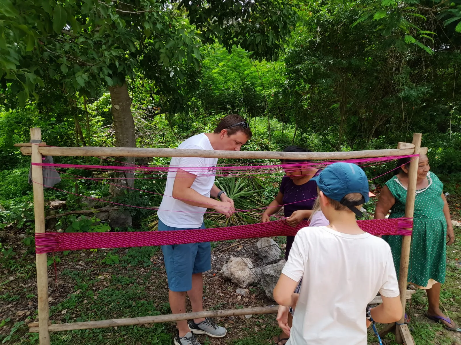 Tejido de una hamaca en el bastidor, bajo los árboles